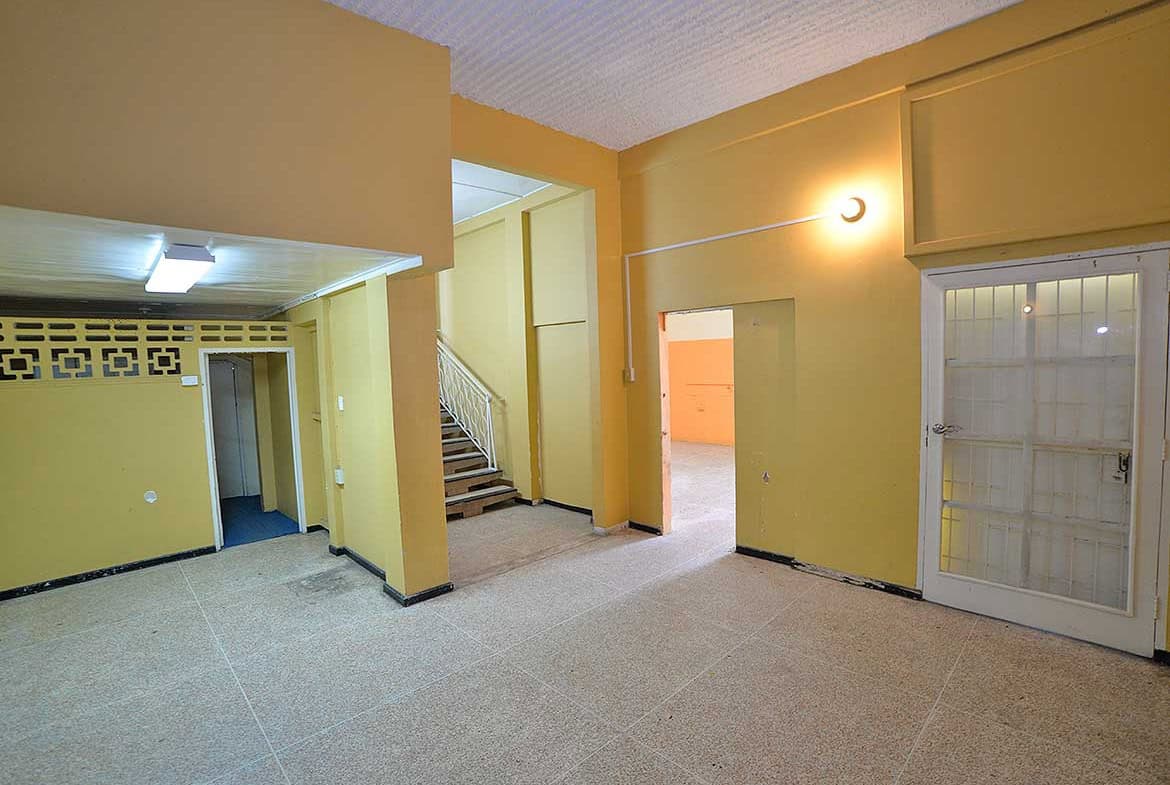 Cornerstone- Spacious interior of Cornerstone™ property in Curepe with yellow walls and staircase.