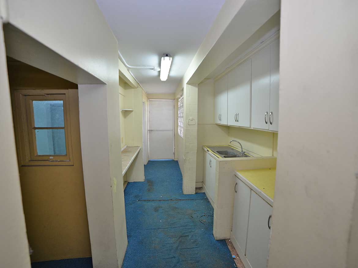 Compact Kitchen Space at Sellier Street Cornerstone- Small kitchen with white cabinets and blue flooring in Curepe.
