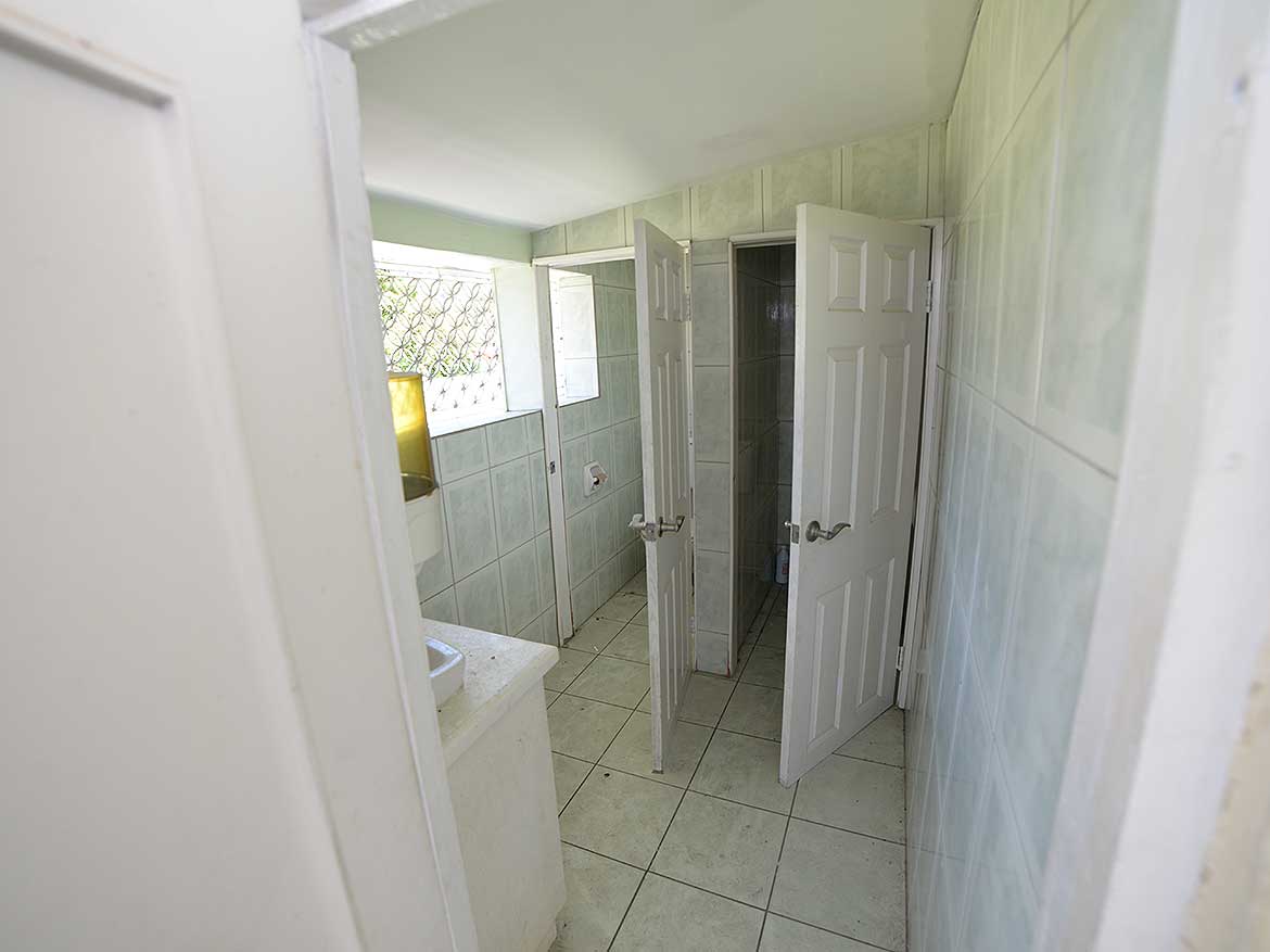 Cornerstone™ Sellier Street, Curepe Bathroom Cornerstone- Bathroom with open door, tiled walls and small window in Curepe.