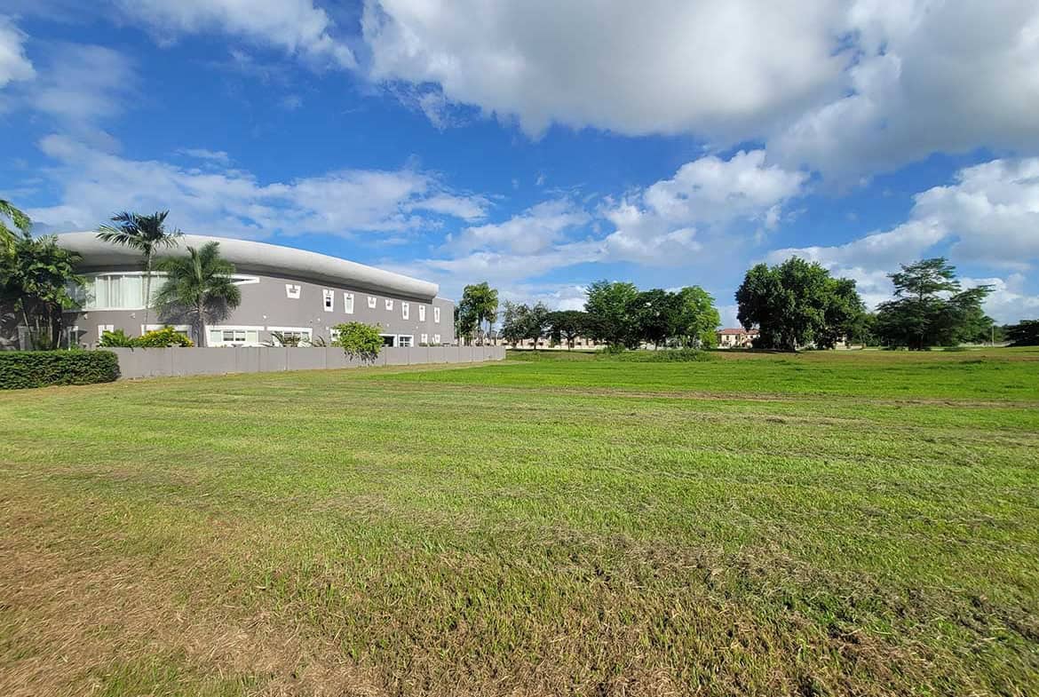 Cornerstone- Open field with Villas at Millennium Lakes in the background under blue sky.