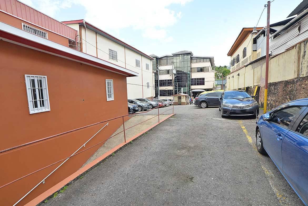 Cornerstone- Parking lot on St James Street with cars and surrounding buildings.