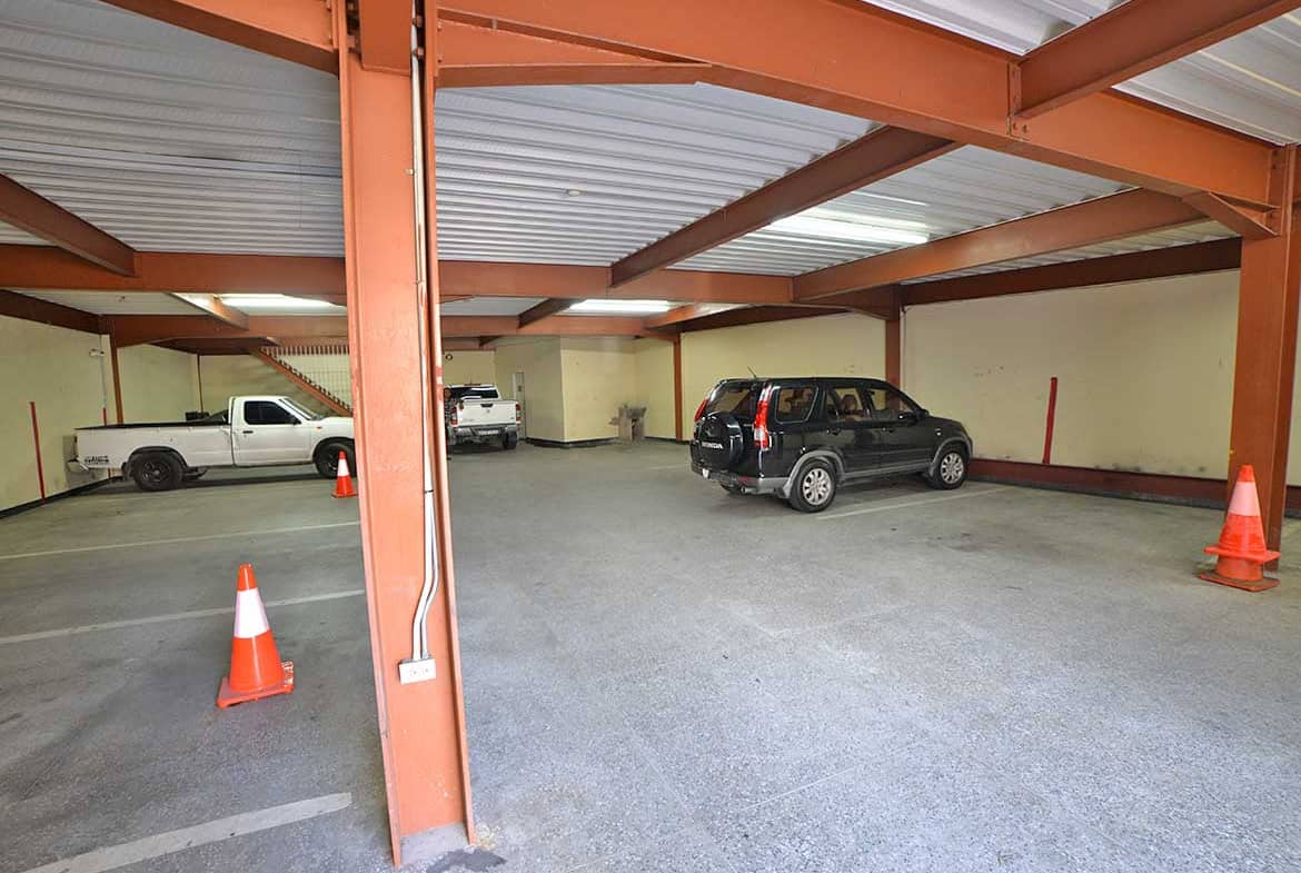 Cornerstone- Underground parking garage with cars and orange safety cones.