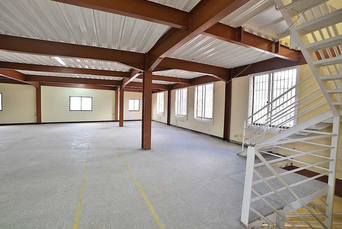 Cornerstone- Open industrial space with large windows and metal staircase at Cornerstone.