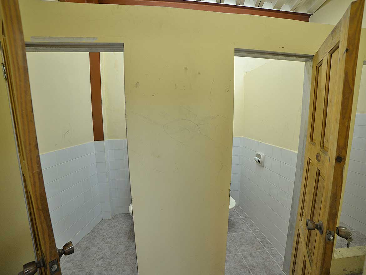 Public Restroom on St James Street Cornerstone- Public restroom with two stalls and wooden doors on St James Street.