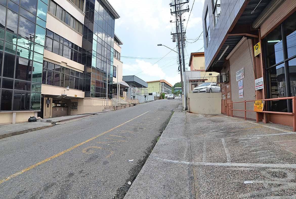 Cornerstone- Empty street in St James with modern buildings and utility poles.