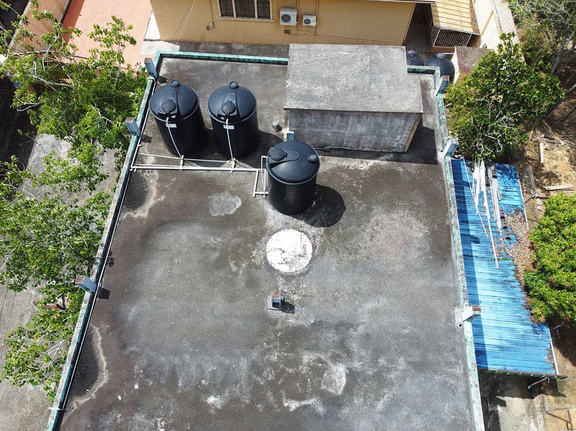 Rooftop Water Tanks in Urban Setting Cornerstone- Aerial view of rooftop water tanks and equipment on a building.