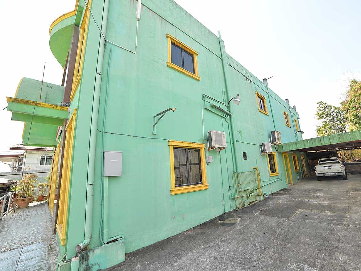 Cornerstone™ Building on Bonne Aventure Road Cornerstone- Colorful green building with yellow window frames on Bonne Aventure Road.