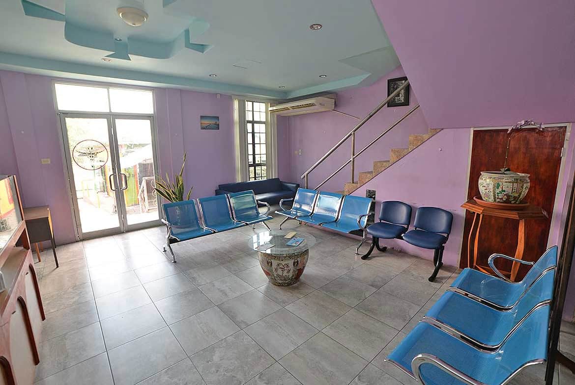 Cornerstone- Modern office lounge with purple walls and blue chairs for visitors.