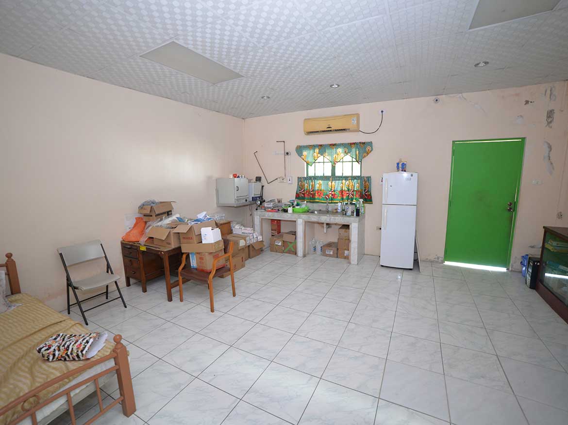 Interior of a modest living space Cornerstone- Simple room with furniture, boxes, and a green door.