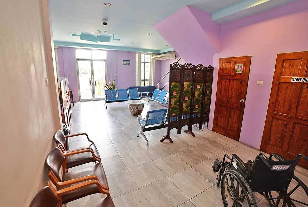 Cornerstone- Interior of a care facility with seating and wheelchair near doors.