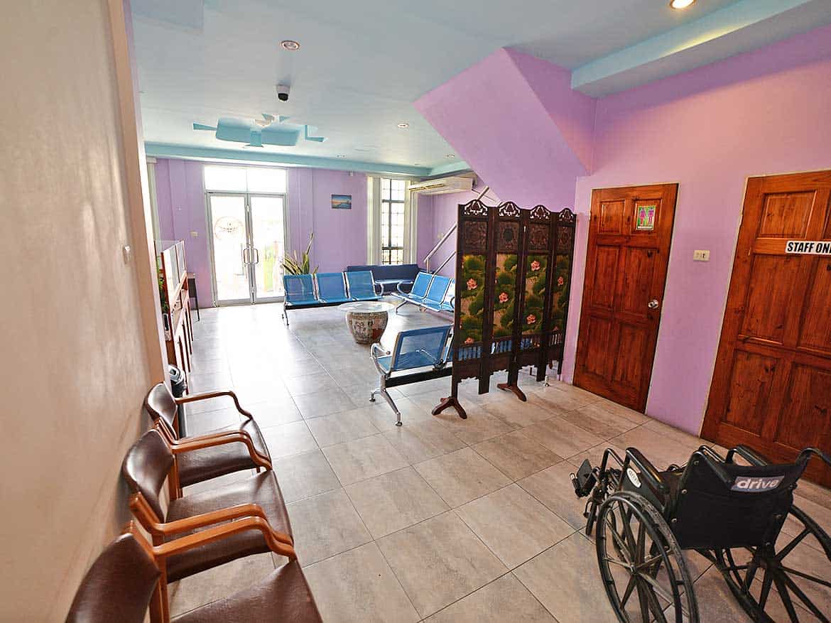 Cornerstone™ Bonne Aventure Road Cornerstone- Interior of a care facility with seating and wheelchair near doors.