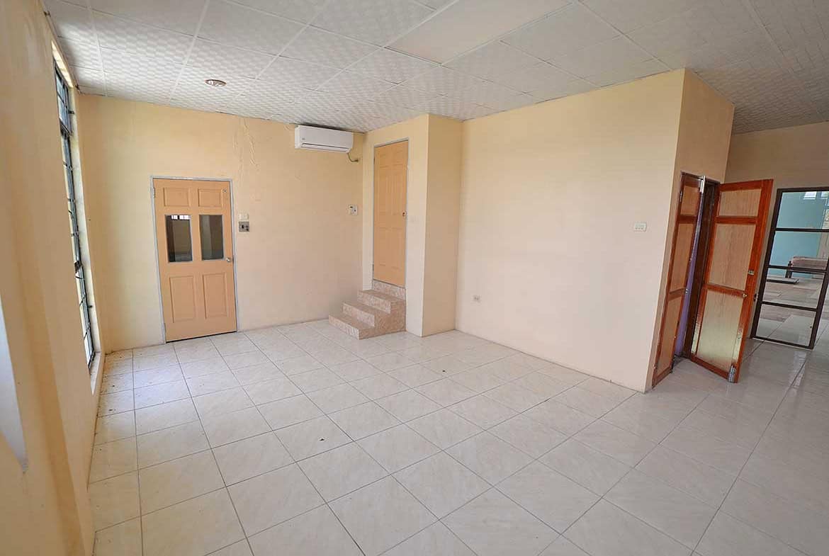 Cornerstone- Spacious room with tiled floor, air conditioning, and multiple doors.