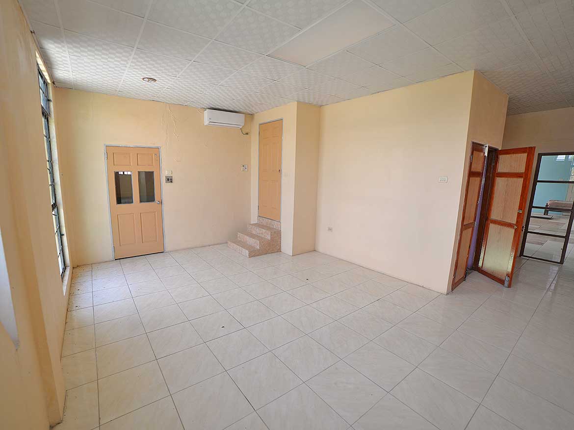 Interior of a Modern Commercial Space Cornerstone- Spacious room with tiled floor, air conditioning, and multiple doors.