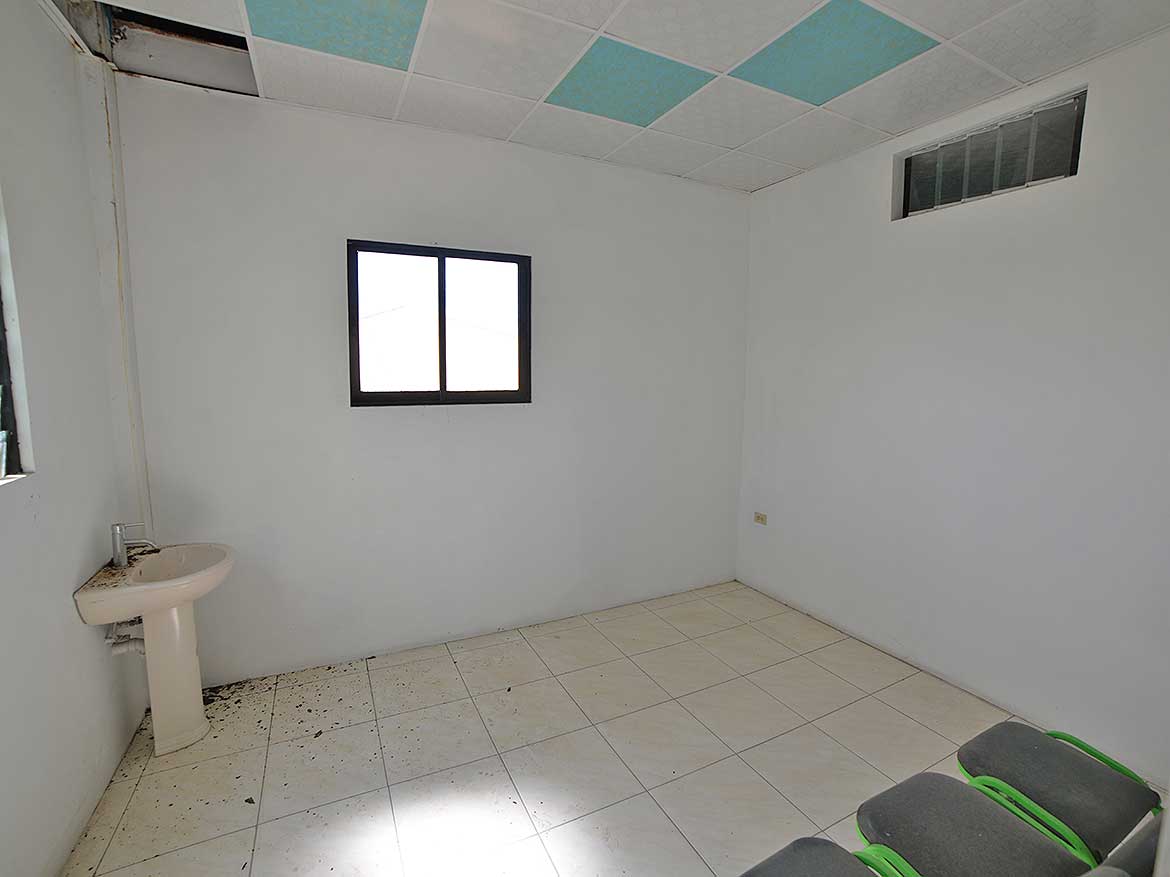 Interior of a Renovated Room Cornerstone- Empty room with white walls, tiled floor, and a window.