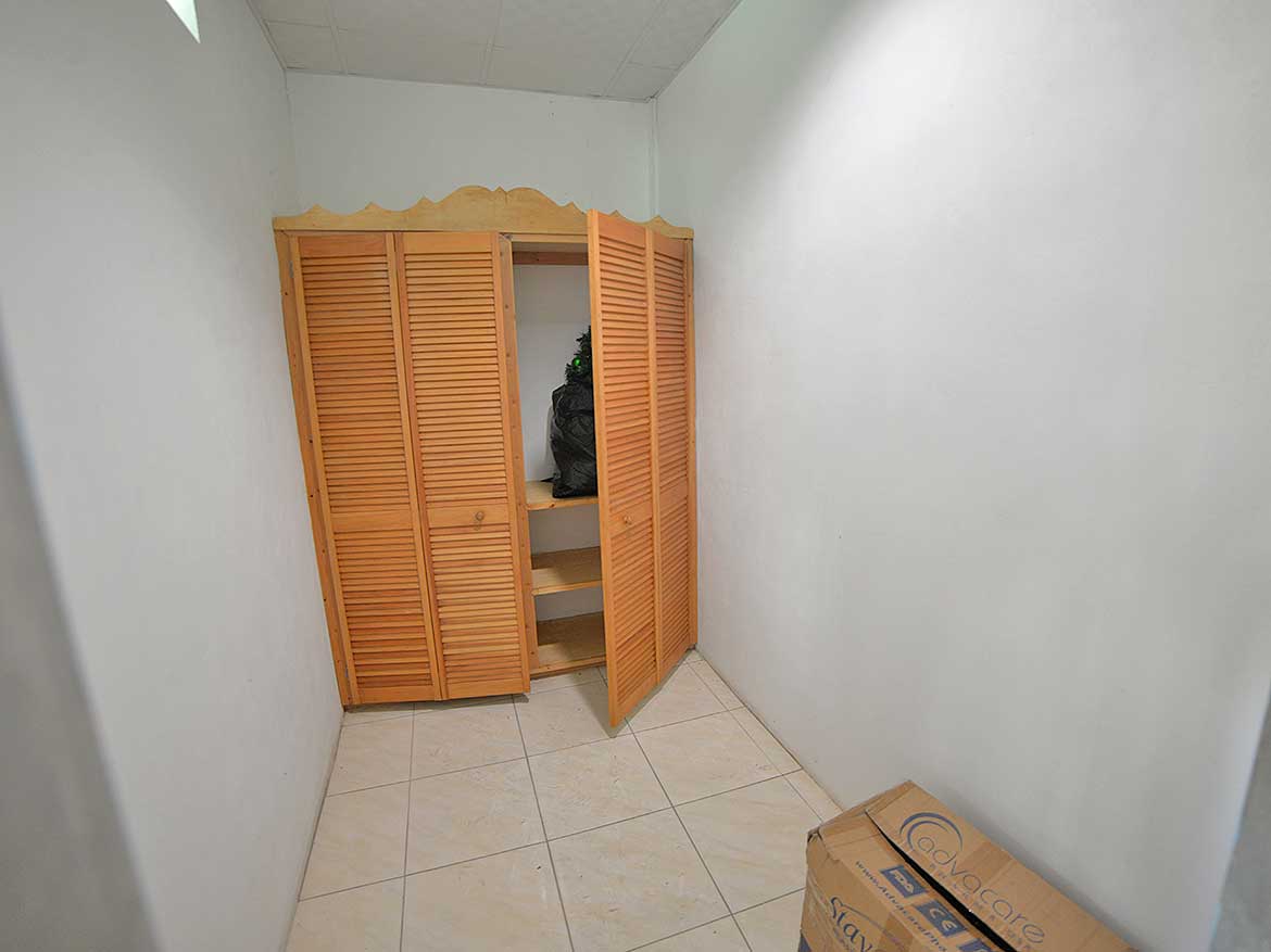 Cornerstone™ Storage Closet Cornerstone- Small storage closet with wooden louvered doors in a white room.