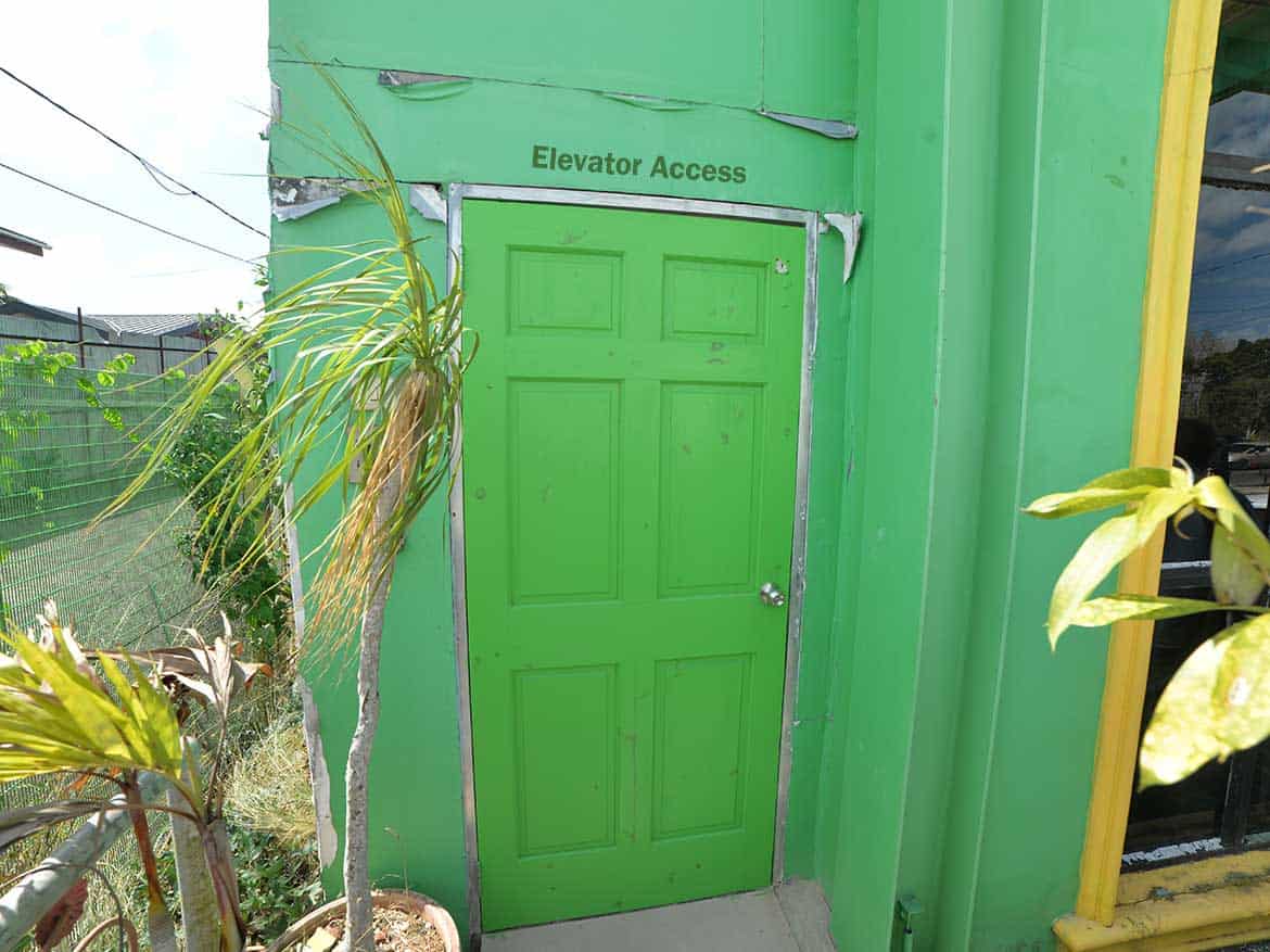 Bright Green Elevator Access Door Cornerstone- Bright green elevator access door with sign above for entry.