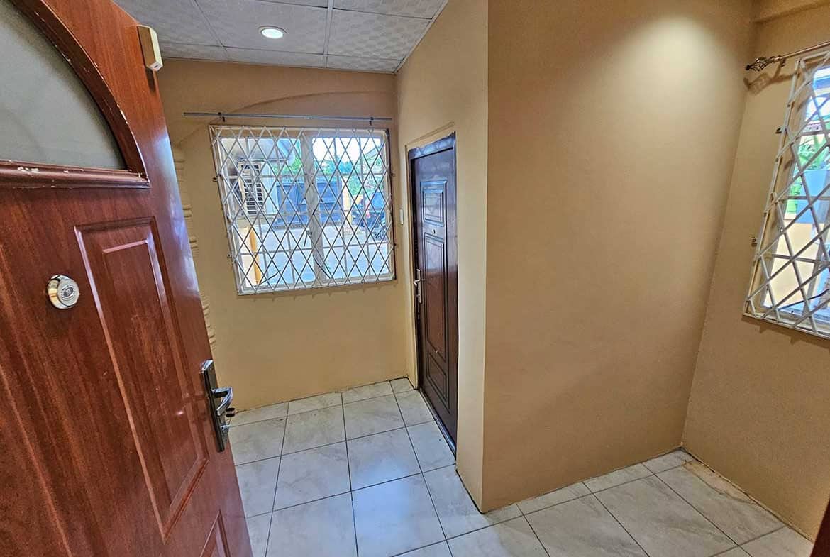 Cornerstone- Interior view of Calcutta Road Apt 1 with windows and tiled floor.