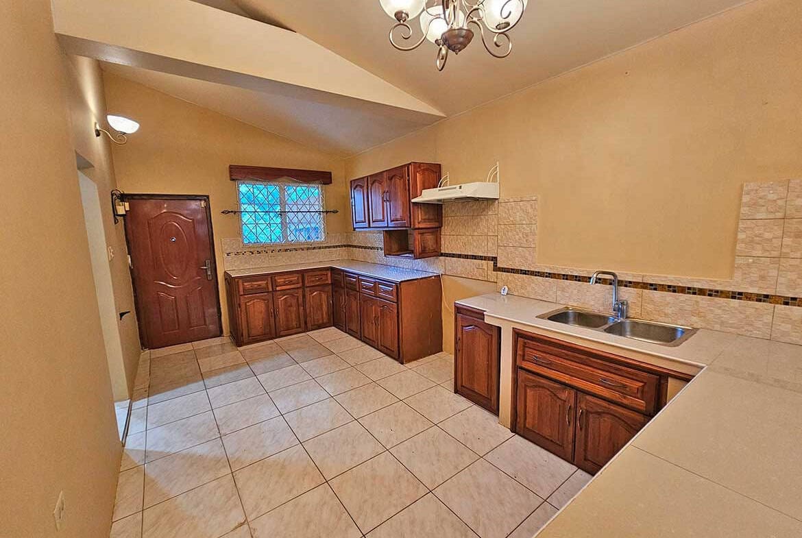 Cornerstone- Bright kitchen with wooden cabinets and tiled flooring in Calcutta Road Apt 1.