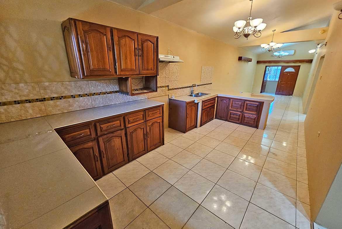 Cornerstone- Bright, spacious kitchen with wooden cabinets and tiled flooring in Calcutta Road Apt 1.