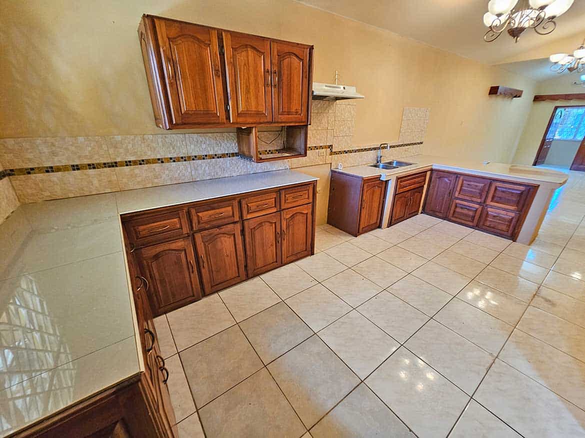 Spacious Kitchen with Wooden Cabinets Cornerstone- Bright kitchen with wooden cabinets, tiled floor, and modern fixtures.
