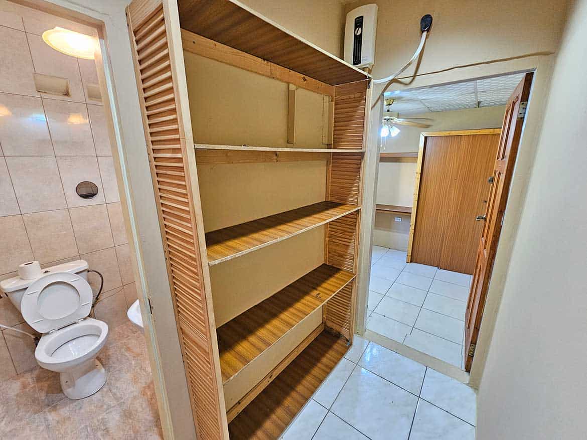 Cornerstone™ Storage Shelf in Apartment Cornerstone- Wooden storage shelf in apartment with bathroom nearby.