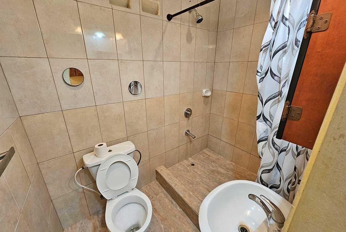 Cornerstone- Small bathroom with shower, toilet, and sink in Calcutta Road Apt 1.