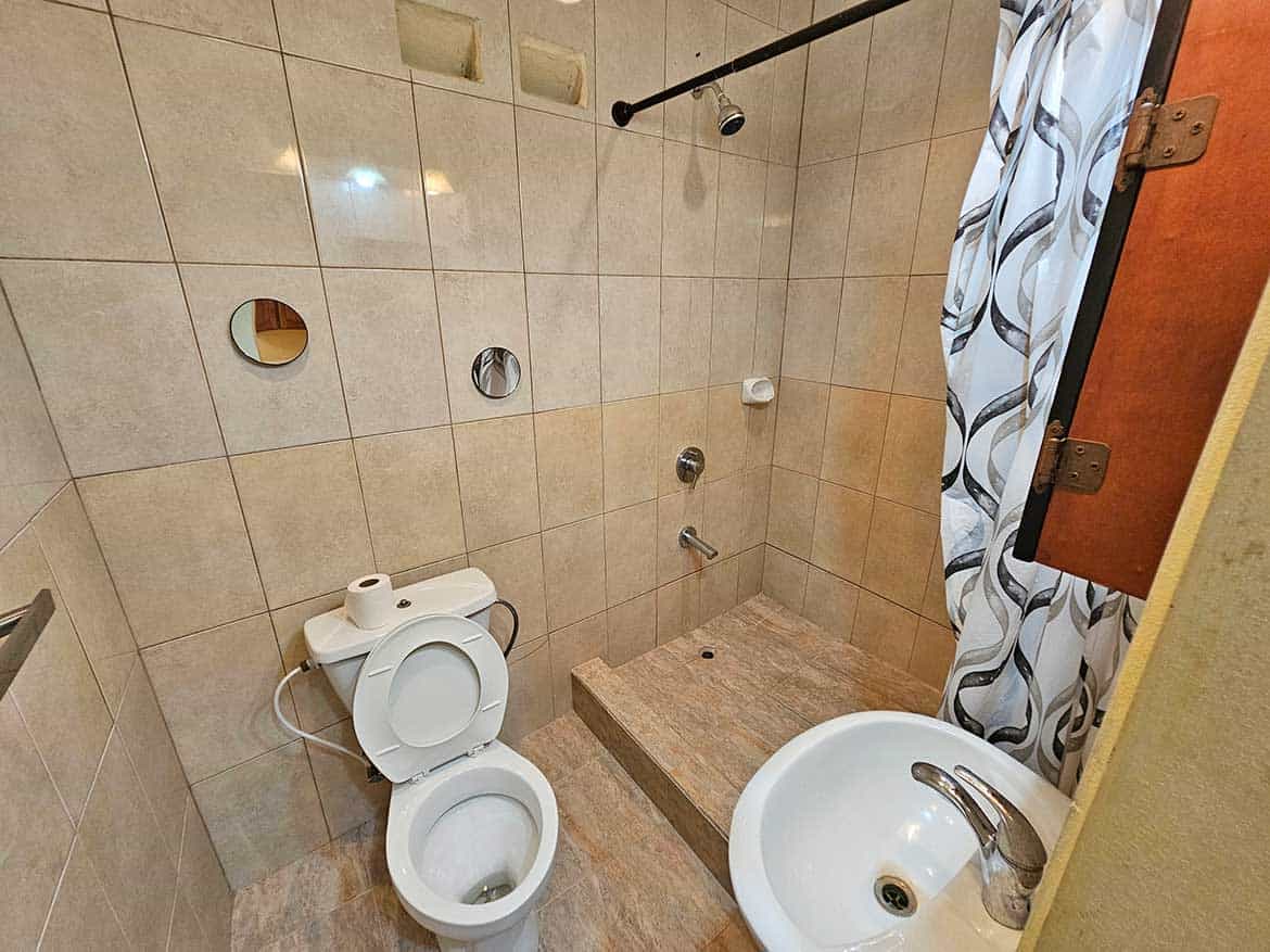 Bathroom in Calcutta Road Apt 1 Cornerstone- Small bathroom with shower, toilet, and sink in Calcutta Road Apt 1.