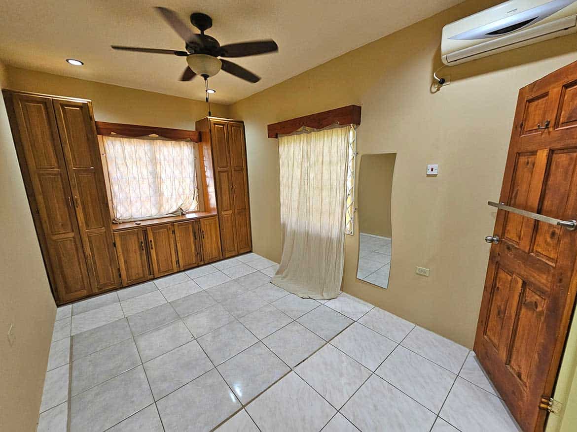 Calcutta Road Apt 1 Interior View Cornerstone- Spacious room with wooden window shutters and ceiling fan in Calcutta Road Apt 1.