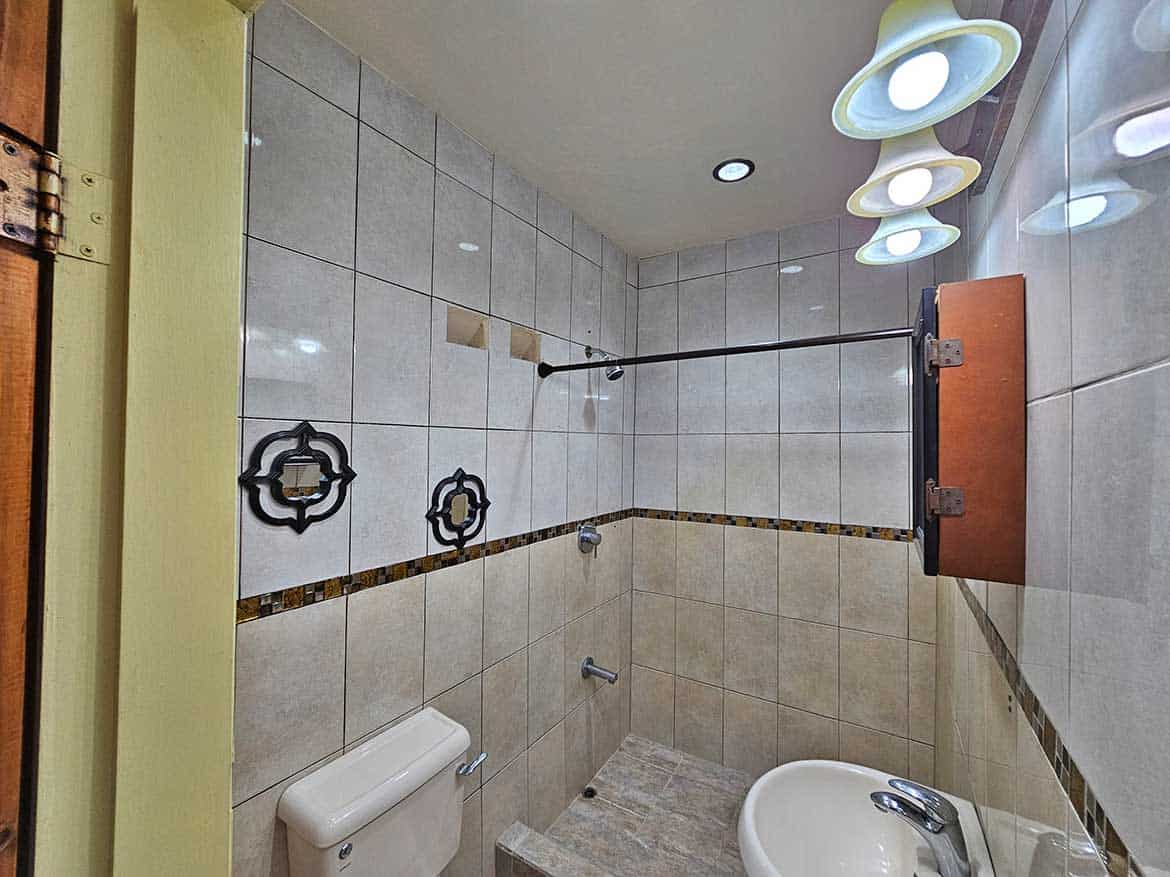Modern Bathroom with Unique Lighting Cornerstone- Contemporary bathroom with stylish lighting and tiled walls.