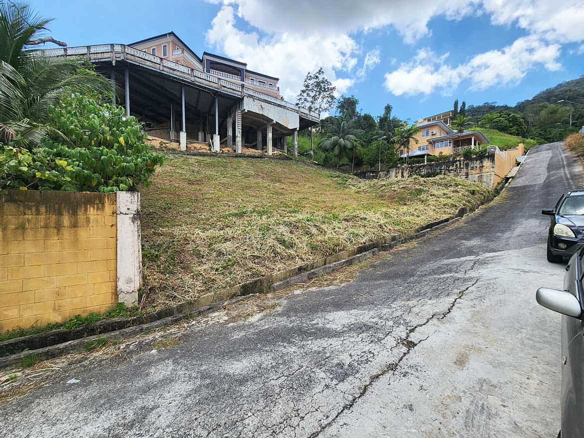 Hilly residential area at Graceland Heights Cornerstone- Steep street with houses and lush greenery in Graceland Heights.