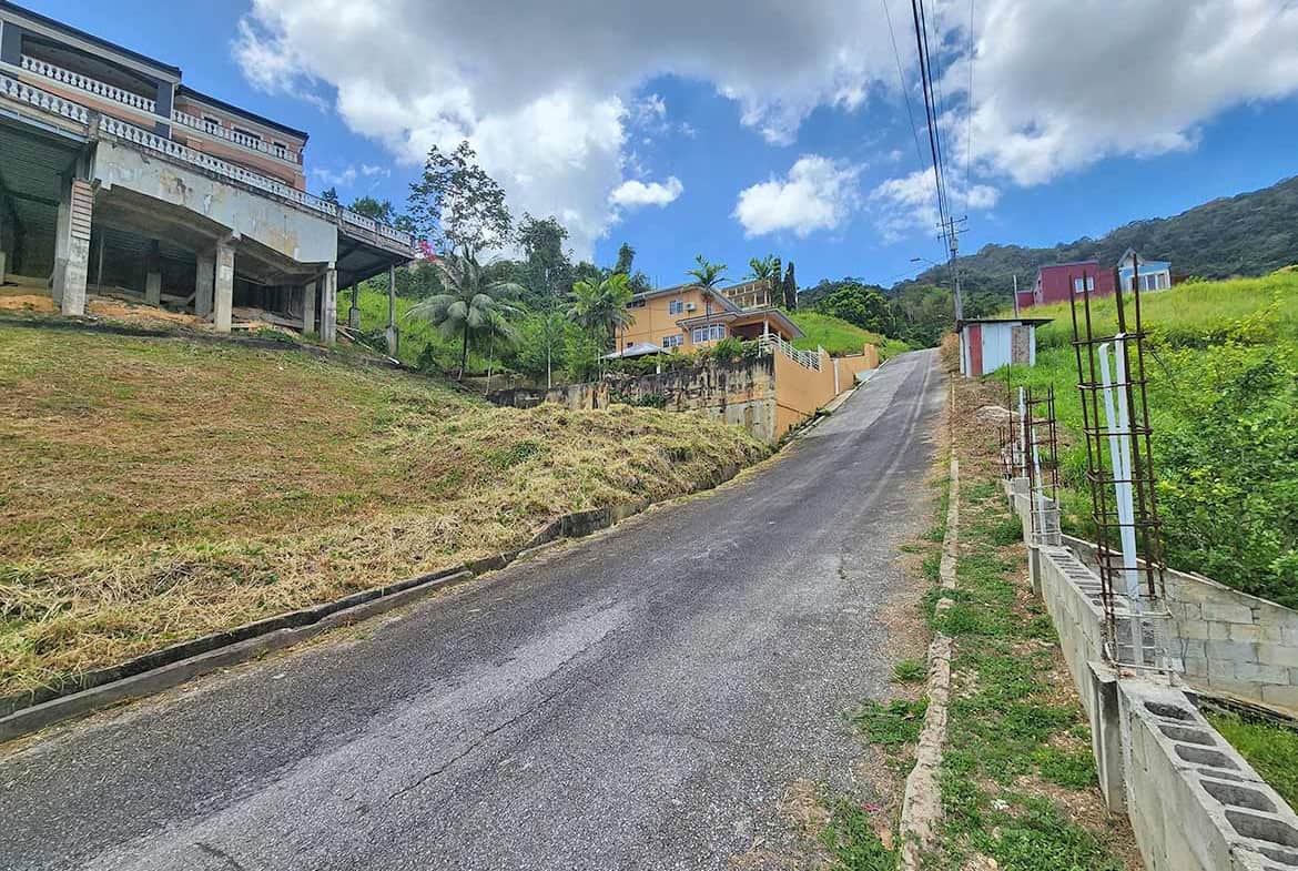 Cornerstone- Hilly street in Graceland Heights with houses and lush greenery.