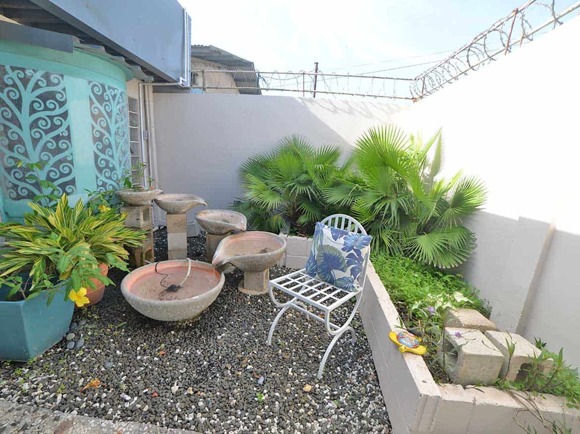 Outdoor Garden Space at Cornerstone Cornerstone- Small outdoor garden with water fountain, plants, and seating area.