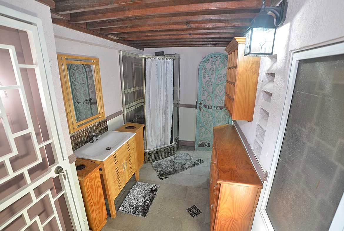 Cornerstone- Cozy bathroom with shower, sink, and wooden cabinets in a 1-bedroom apartment.
