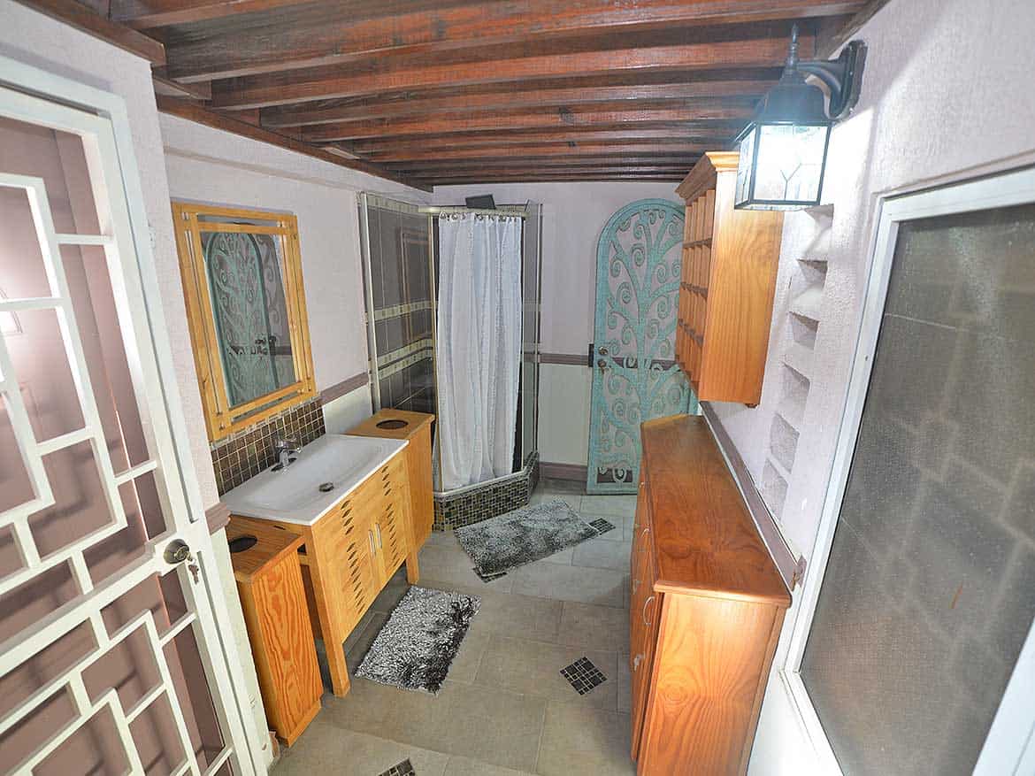 Bathroom in 1-Bedroom Apartment Cornerstone- Cozy bathroom with shower, sink, and wooden cabinets in a 1-bedroom apartment.