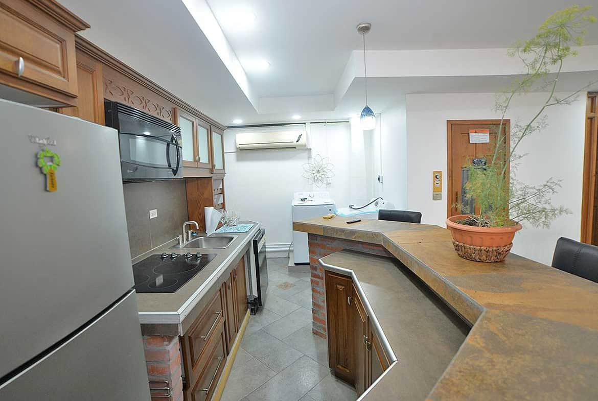 Cornerstone- Contemporary kitchen with wooden cabinets, stainless steel appliances, and a breakfast bar.