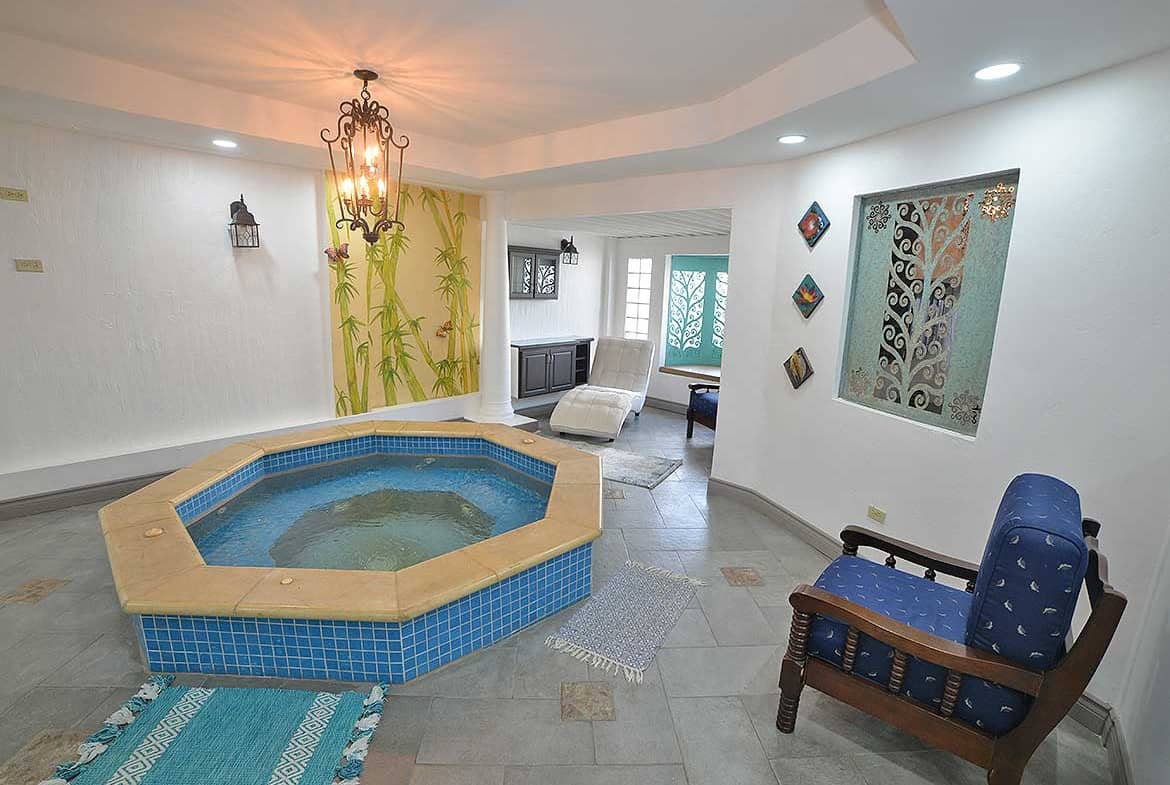 Cornerstone- Spacious apartment with hot tub, seating area, and decorative wall art.