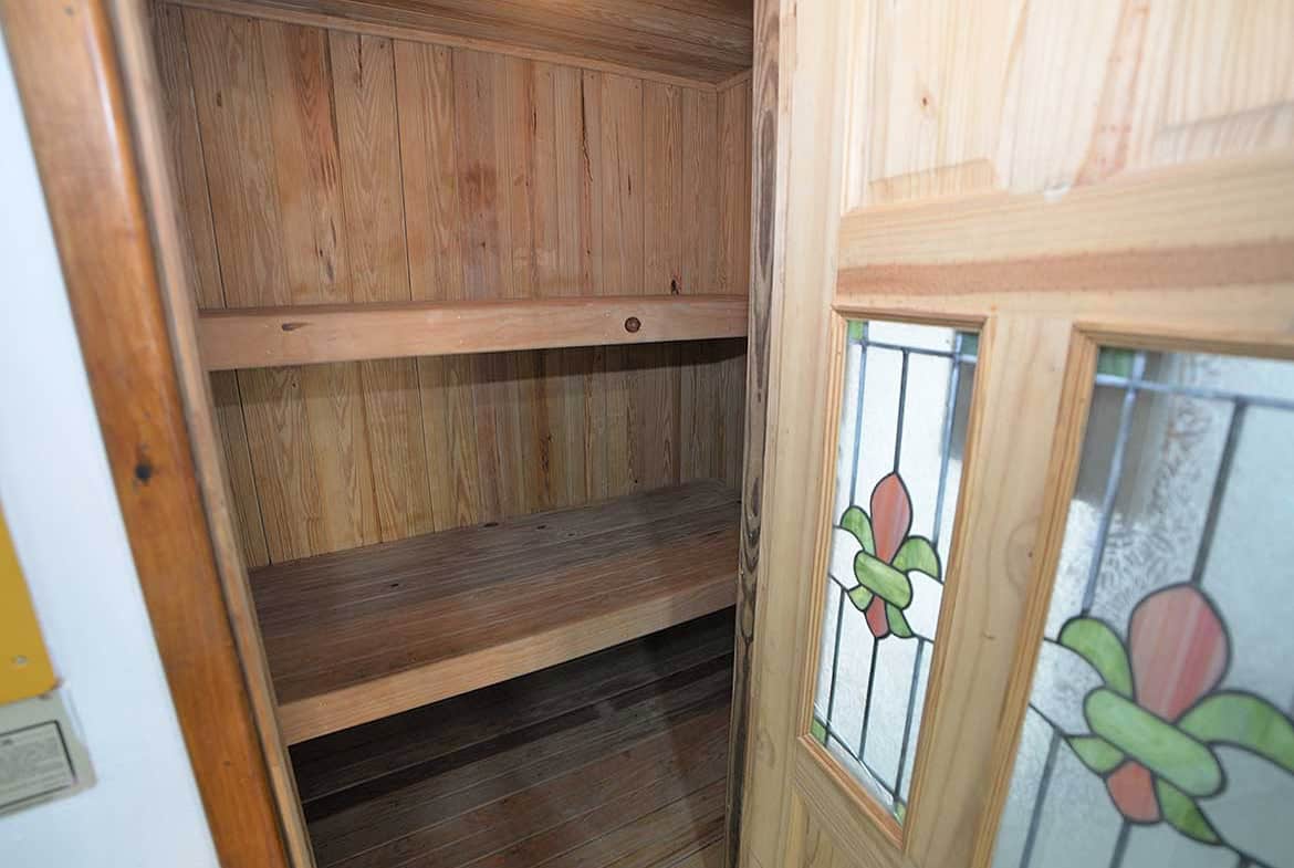 Cornerstone- Small wooden closet with stained glass window in a modern apartment.