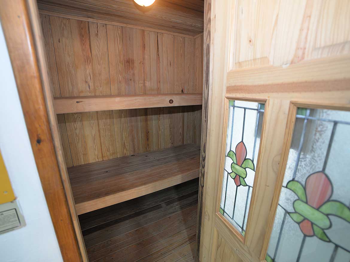 Cozy Wooden Storage Closet Cornerstone- Small wooden closet with stained glass window in a modern apartment.