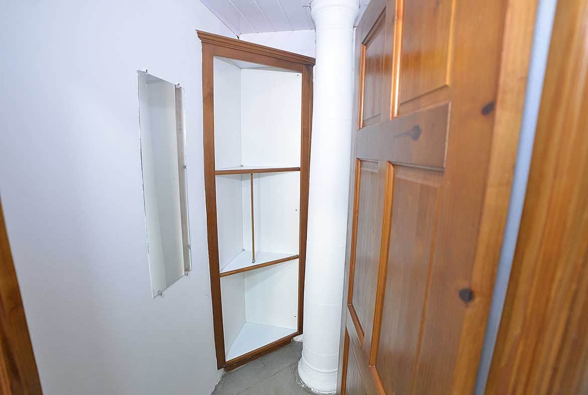 Cornerstone- Small built-in corner shelf in a 1-bedroom apartment.