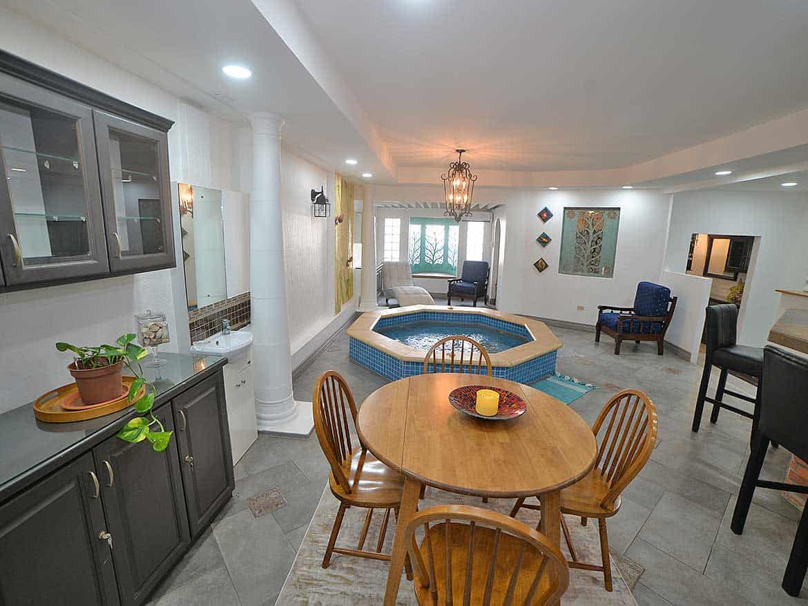 Spacious Living Area with Hot Tub Cornerstone- Interior view of a living room with hot tub, dining area, and seating.