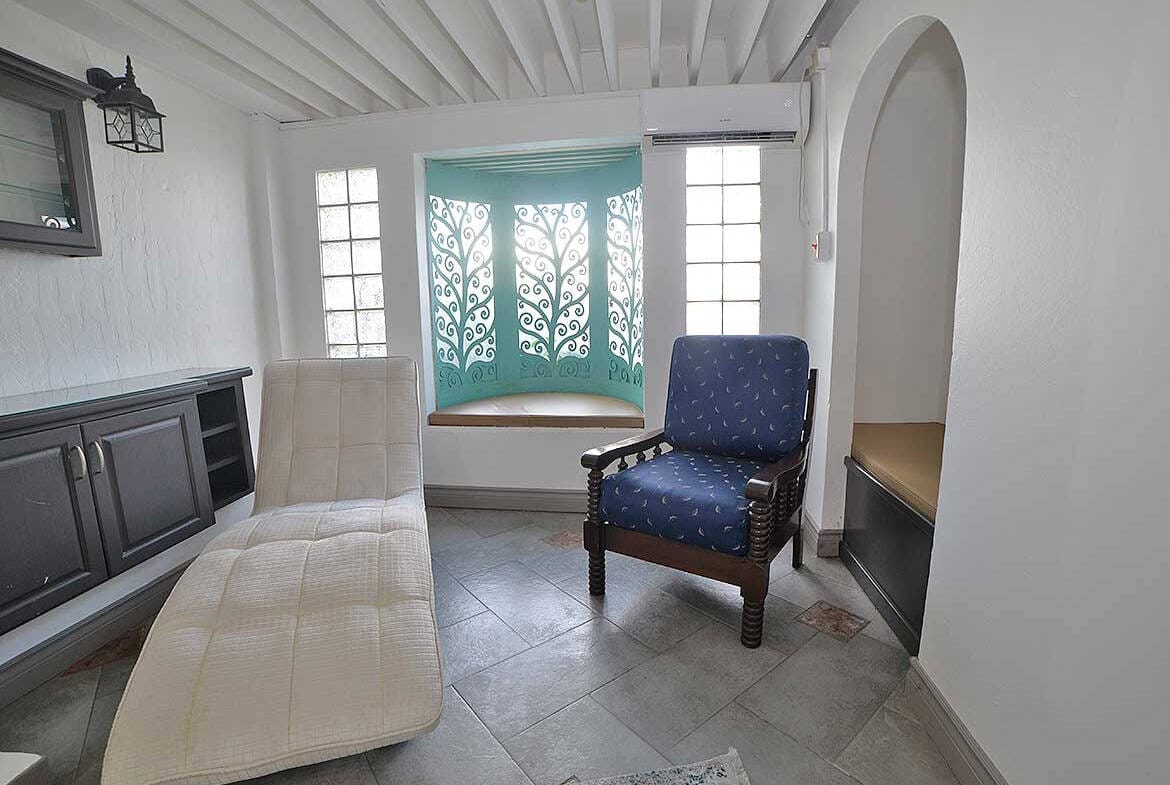 Cornerstone- Bright living room with comfortable seating and decorative window.
