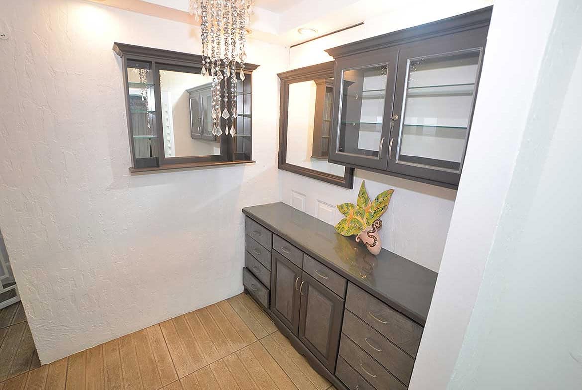 Cornerstone- Contemporary kitchen with dark cabinetry and a chandelier.
