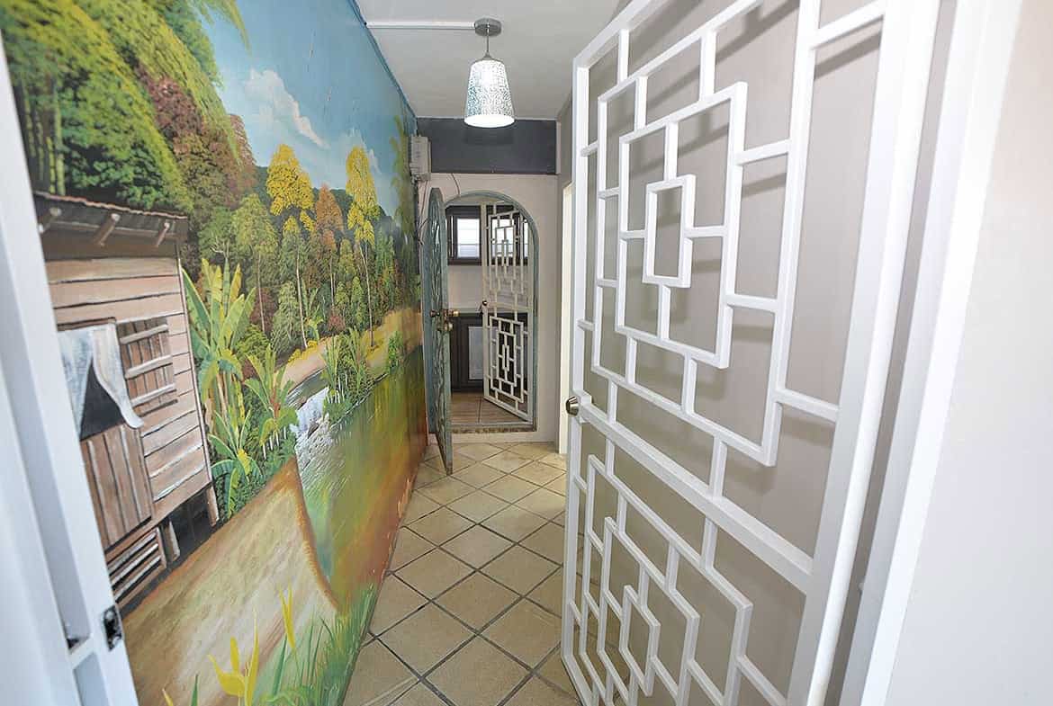Cornerstone- Modern apartment hallway with decorative wall art and geometric room divider.