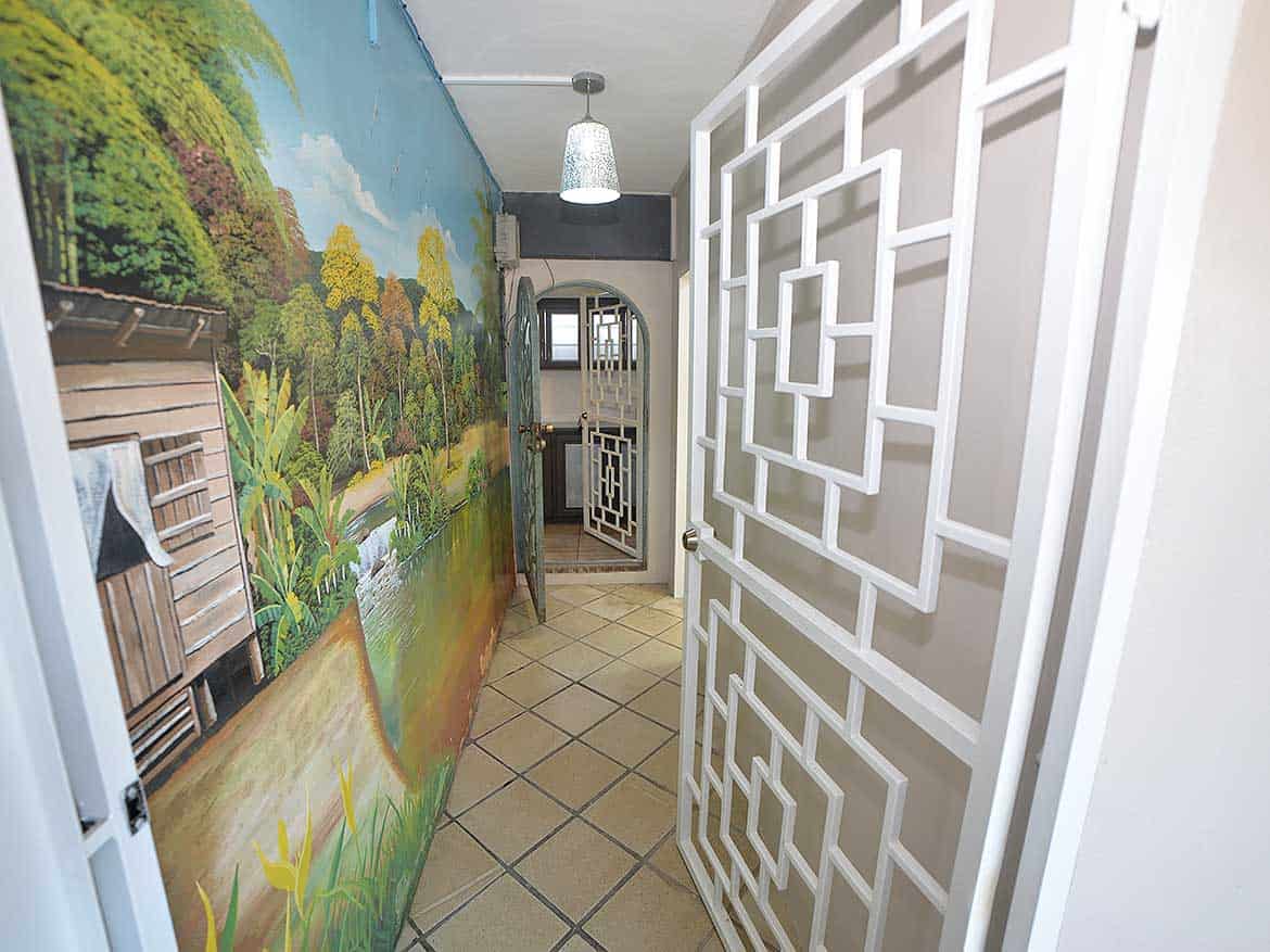 Interior View of 1-Bedroom Apartment Cornerstone- Modern apartment hallway with decorative wall art and geometric room divider.
