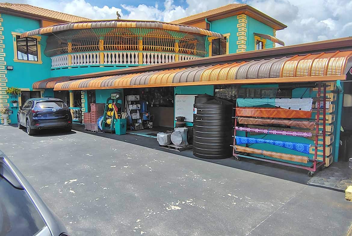 Cornerstone- Colorful commercial building with retail space and parking area.