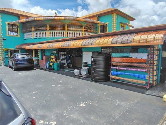 Cornerstone- Colorful commercial building with retail space and parking area.