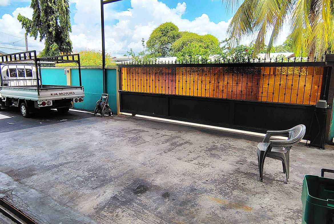 Cornerstone- Outdoor view of residence with retail space, gate, and parking area.