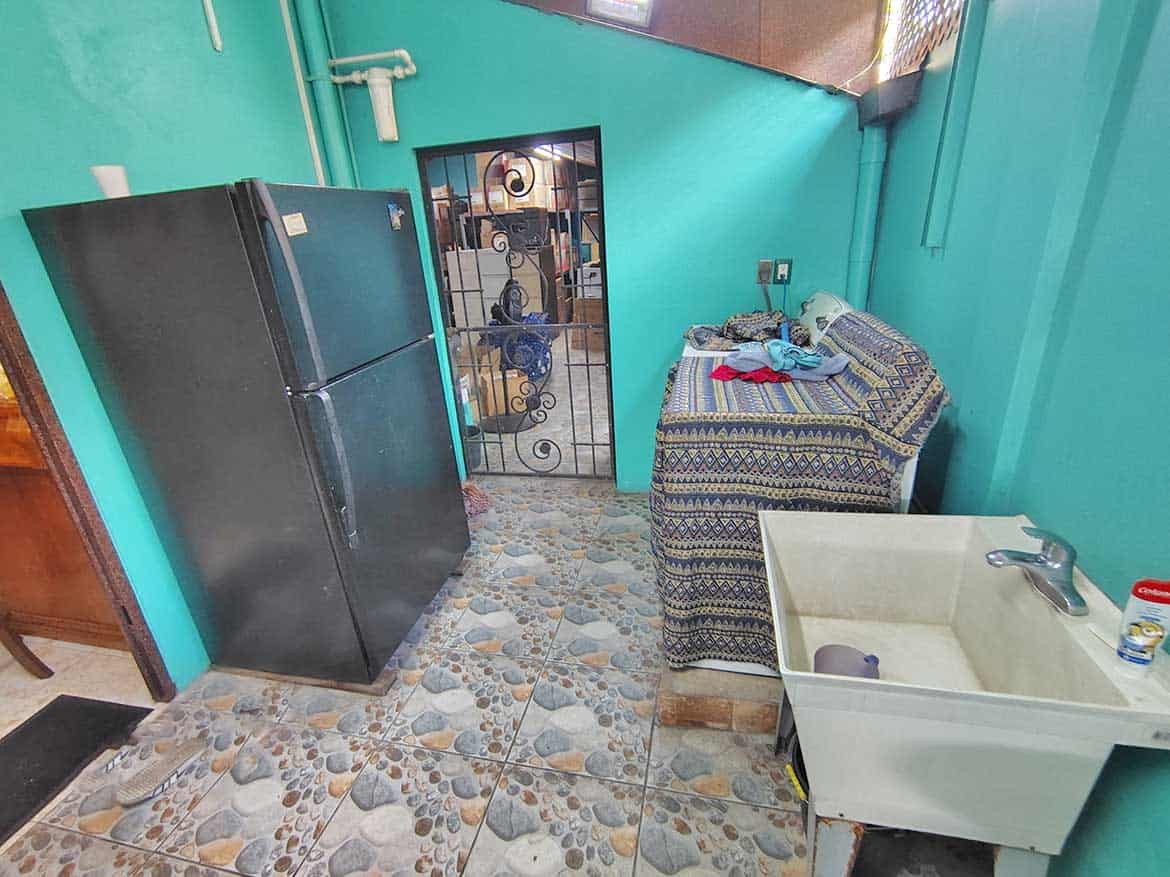 Laundry Area in Residence with Retail Space Cornerstone- Laundry room with refrigerator, sink, and laundry supplies in residence with retail space.