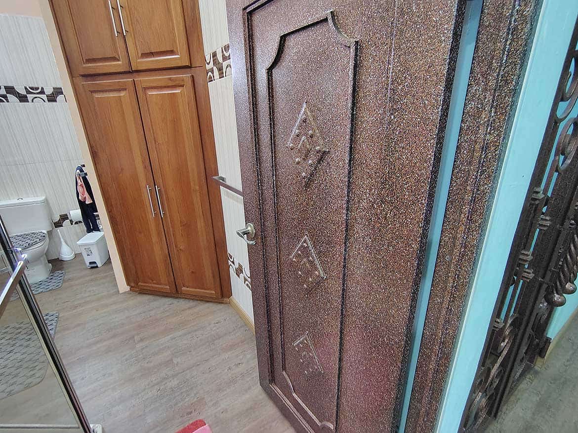 Residential Door with Retail Space Cornerstone- Residential door with decorative design in a home with wooden cabinets.
