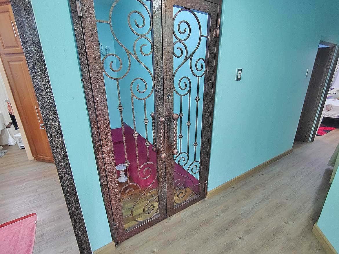 Elegant Interior Door with Decorative Ironwork Cornerstone- Decorative iron door with glass panels in a modern residence.